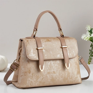 Close-up of champagne gold tote bag showing vertical stripe texture and metal hardware