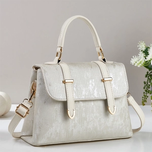 Detail of cream white tote bag with vertical texture and gold metal buckle hardware