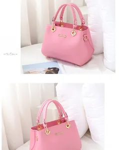 Detailed view of pale pink lychee-grain leather tote bag featuring golden hardware accents