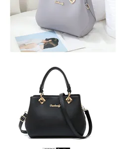 Detail of elegant leather tote bag with dual circular handles and golden logo plaque