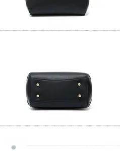 Detail view of black faux leather handbag showing textured finish and bottom gold studs