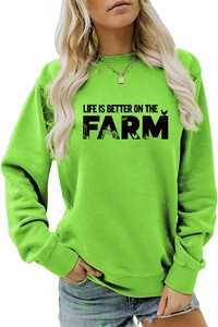 Detail of rib-knit cuffs and hem on bright green Life Is Better On The Farm sweatshirt