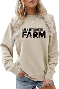 Detailed close-up of Life Is Better On The Farm text and tractor print on beige sweatshirt