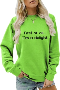 Detail of the neon green sweatshirt showing the 'First of all' black lettering and texture