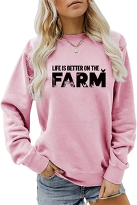 Detail of pink crewneck sweatshirt featuring black 'LIFE IS BETTER ON THE FARM' print
