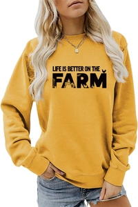 Detail of ginger yellow sweatshirt featuring farm silhouette print and ribbed cuffs