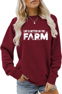 Close-up of burgundy sweatshirt featuring Life is Better on the Farm print with ribbed cuffs