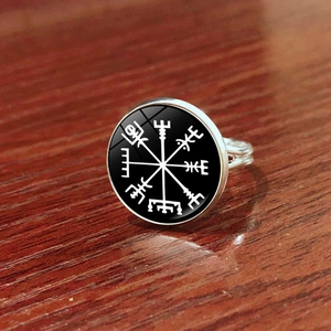 Makroaufnahme des silbernen Wikinger Vegvisir Kompass Rings auf dunklem Holz