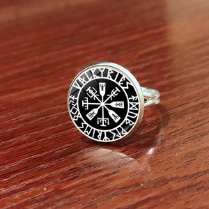 Makroansicht des Wikinger-Vegvisir-Kompassrings mit Valkyries-Gravur auf Holzhintergrund