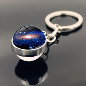 Macro view of solar system galaxy glass ball keychain with silver metal ring and reflection