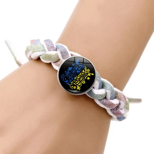Gros plan d'un bracelet tissé avec pendentif en verre aux motifs floraux bleus et jaunes