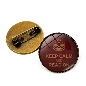 Macro detail van Keep Calm badge met glazen koepel en bronzen metalen speldzijde