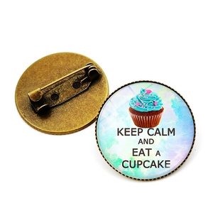 Detail van bronzen broche met Keep Calm and Eat a Cupcake ontwerp en speldsluiting