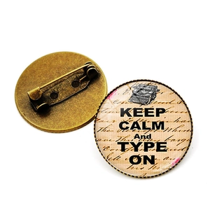 Voor- en achteraanzicht van de bronzen Keep Calm and Type On-speld met handige sluiting