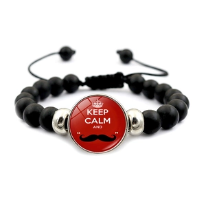 Detail eines schwarzen Perlenarmbandes mit rotem Keep Calm Glasanhänger und verstellbarem Band