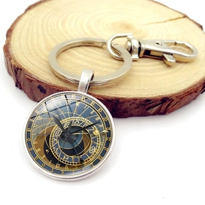 Macro shot of Prague Astronomical Clock keychain with silver lobster clasp on a wood slice
