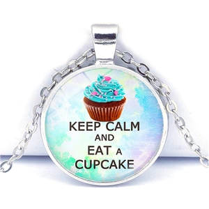 Close-up of glass pendant with Keep Calm and Eat a Cupcake text on blue watercolor