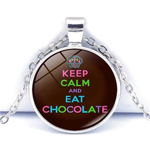 Macro shot of glass cabochon pendant with Keep Calm and Eat Chocolate quote