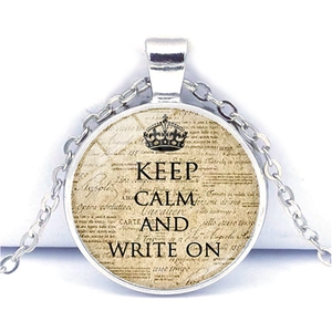 Macro shot of vintage silver-toned Keep Calm necklace with glass gem and crown detail