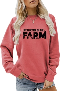 Detail of coral crewneck sweatshirt featuring Life Is Better On The Farm graphic print