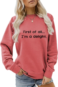Close-up of salmon pink sweatshirt featuring black First of all I'm a delight slogan print