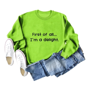 Detailed flat lay of green crewneck sweatshirt with First of all text print and denim jeans