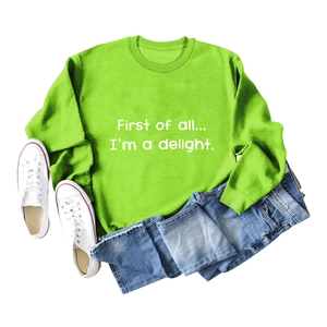 Flat lay of bright green crewneck sweatshirt featuring white artistic letter printing