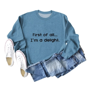 Flat lay of a misty blue crewneck sweatshirt with 'First of all' black letter print