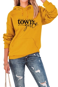 Detail van mosterdgele hoodie met just a small town girl print en een handige kangoeroezak