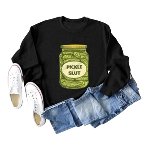 Flat lay of black crewneck sweatshirt with yellow Pickle Slut print and casual outfit