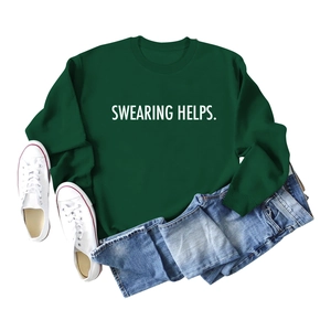 Mise à plat d'un sweat vert foncé avec imprimé SWEARING HELPS, short en jean et baskets