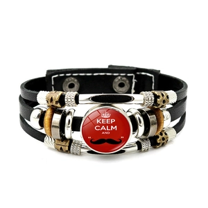 Detail view of multilayer braided leather bracelet with Keep Calm quote and metal charms