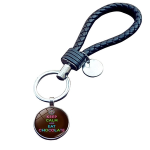 Detail of woven leather keychain with Keep Calm and Eat Chocolate glass pendant