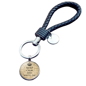 Detail view of woven black leather keychain with Keep Calm and Write On pendant