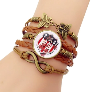 Detail eines mehrlagigen Lederarmbands mit Schmetterling und Route 66 Anhänger