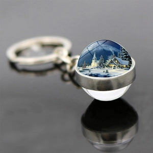 Vista macro di un portachiavi a sfera di vetro con paesaggio natalizio e neve