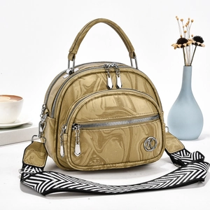 Detail of beige marble pattern handbag with multi-layer zippers and wide strap
