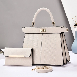 Detailed view of cream pebble leather handbag set with gold hardware and woven texture