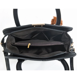 Interior view of black handbag showing multiple compartments and golden hardware detail