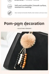 Détail du sac à main en similicuir noir avec pendentif ajustable en perles et fourrure