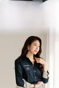 Détail de la chemise bleu foncé avec col rayé et broderie de camélia blanc