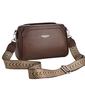 Dark brown textured leather crossbody bag with a chevron patterned wide canvas shoulder strap