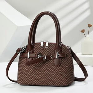 Detail of herringbone fabric handbag with dual zippers and dark brown leather handles