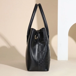 Detail view of the black leather handbag side with textured embossed grid pattern