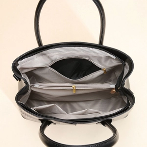 Top view of spacious interior storage with grey lining and multiple pockets in handbag