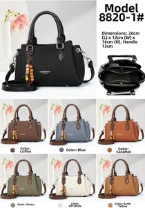 Detail view of multi-compartment PU leather handbag with litchi texture and tassel charm