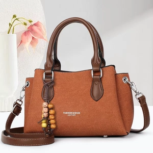 Brown woven tote bag for women with leather handles and decorative wooden bead charm