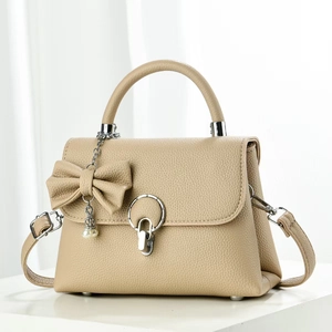 Sac bandoulière beige classique avec rabat, texture litchi et pendentif perle