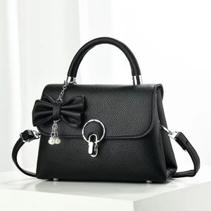 Détail d'un sac à bandoulière en cuir noir avec nœud en perles et boucle argentée chic