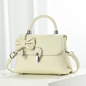 Détail du sac en cuir grainé avec poignée supérieure et pendentif nœud décoratif